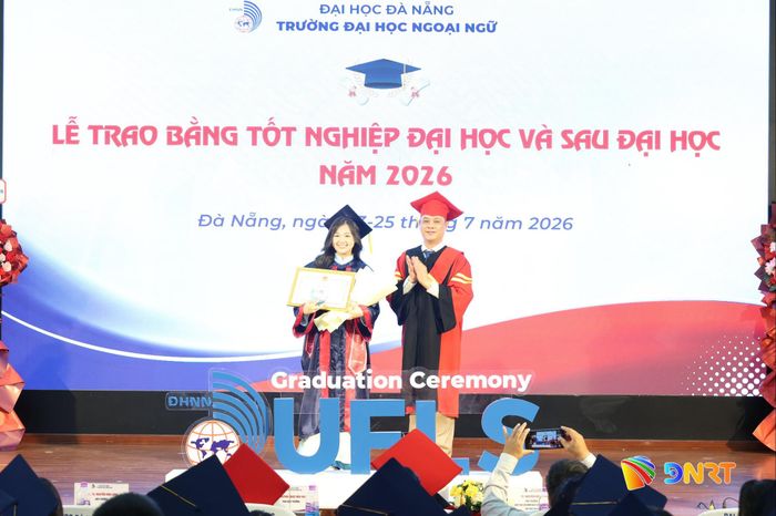 Lãnh đạo Trường Đại học Ngoại ngữ (bên phải) trao giấy khen của Giám đốc Đại học Đà Nẵng cho thủ khoa toàn trường. Ảnh: NGỌC HÀ