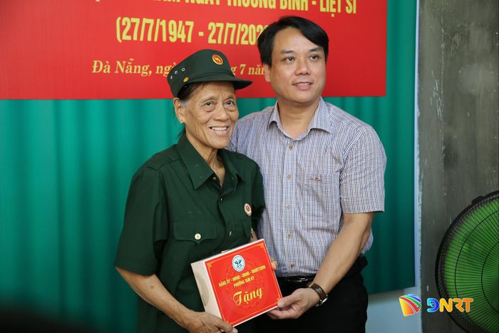 Bà Phan Thị Thanh Xuân đón nhận món quà chúc mừng từ lãnh đạo phường Tam Kỳ trong ngày khánh thành nhà mới. Ảnh: ALĂNG NGƯỚC