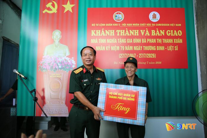 Đại diện lãnh đạo Bộ Chỉ huy Quân sự thành phố tặng quà chúc mừng bà Phan Thị Thanh Xuân. Ảnh: ALĂNG NGƯỚC