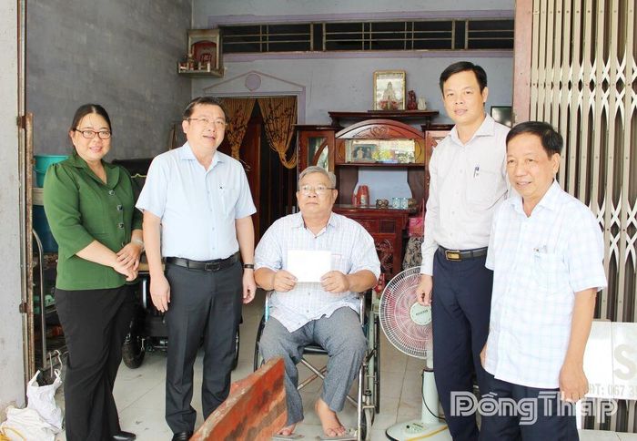 Đồng chí Phan Văn Thương (thứ 2 từ trái sang) tặng quà cho ông Lê Phương Non.