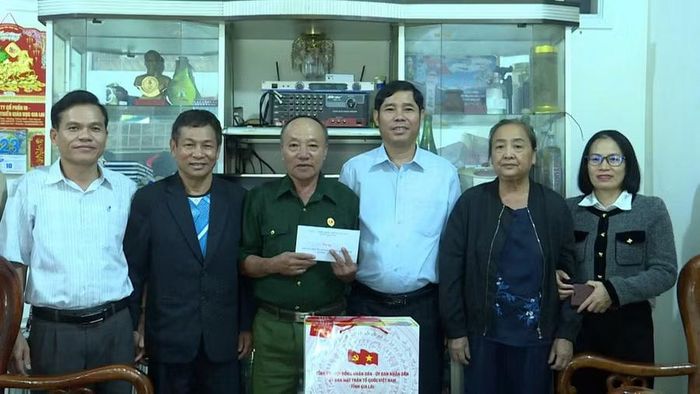  Phó Chủ tịch Thường trực Ủy ban MTTQ Việt Nam tỉnh Trần Minh Sơn (thứ 3 từ phải sang) tặng quà cho thương binh Phạm Hải Chính (tổ 2, phường Thống Nhất). Ảnh: Duy Linh 