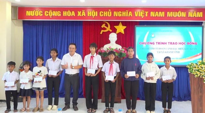 Lãnh đạo UBND xã trao học bổng cho học sinh có hoàn cảnh đặc biệt khó khăn. Ảnh: PHÙNG QUỲNH.