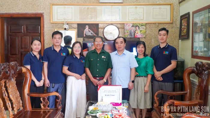 Đoàn công tác chụp ảnh lưu niệm cùng thương binh Nguyễn Văn Tặng 