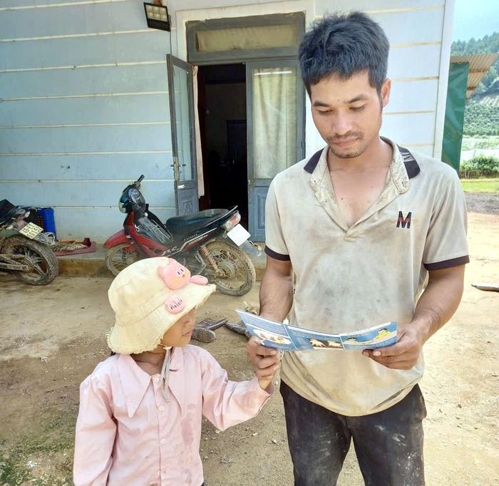 Một người cha đọc tài liệu để biết cách phòng bệnh TCM cho con trẻ trong gia đình