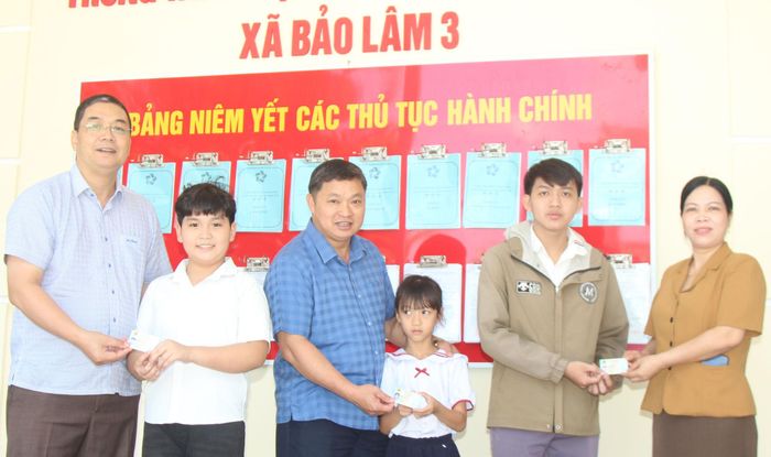 Các đồng chí Nguyễn Đình Bình, Bí thư Đảng ủy, Chủ tịch HĐND xã; Hồng Việt Trung, Chủ tịch UBND xã trao căn cước công dân cho người dân và học sinh tại địa phương
