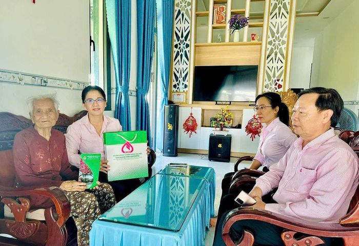 Bà Trần Thị Ngọc Minh, Giám đốc PGD NHCSXH Hàm Thuận Nam thăm, tặng quà tri ân Mẹ Việt Nam Anh hùng Hồ Thị Tư, xã Hàm Kiệm