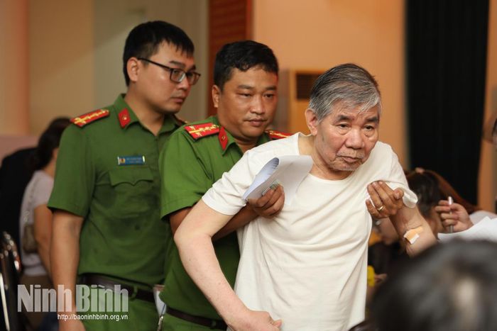 Ông Trần Văn Bân, anh trai liệt sĩ Trần Văn Ân (tổ dân phố Lộc Vượng 7, phường Nam Định), sức khỏe yếu, đi lại khó khăn, được cán bộ Công an phường Nam Định hỗ trợ tại điểm thu nhận mẫu sinh phẩm ADN.