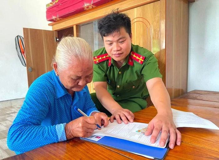 Công an xã Dũng Tiến hướng dẫn thân nhân liệt sĩ kê khai theo mẫu.