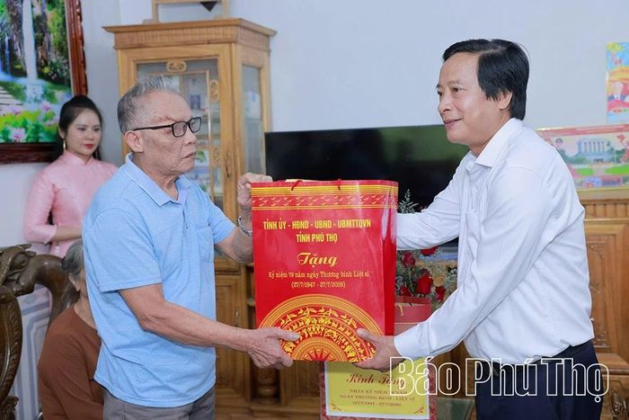 Đồng chí Phó Bí thư Tỉnh ủy Nguyễn Mạnh Sơn trao quà tặng ông Đặng Thế Phúc.