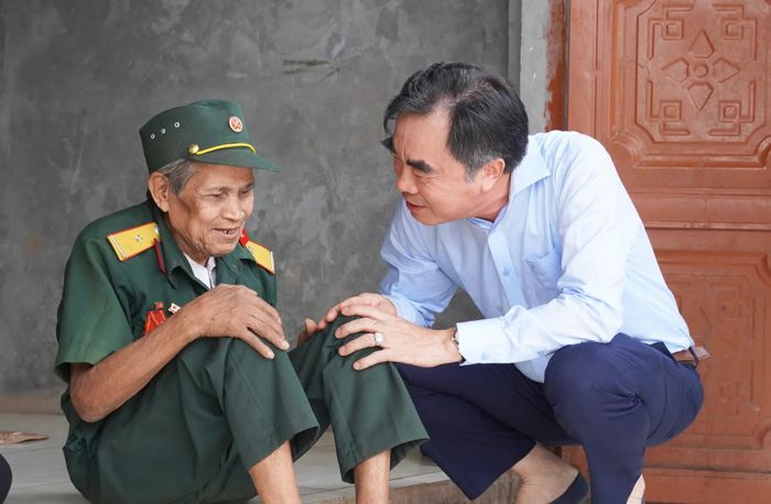 Đồng chí Nguyễn Lương Bình, Trưởng ban Tổ chức Tỉnh ủy thăm hỏi sức khỏe bệnh binh Hồ Văn Đăm, ở thôn Ra Po, xã A Dơi - Ảnh: X.P 