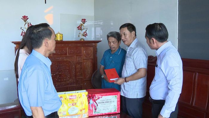 Đồng chí Lê Quang Chiến, Bí thư Đảng ủy phường Đông Hà thăm, tặng quà ông Võ Ngọc Lân, ở xã Cửa Việt - Ảnh: Mai Linh