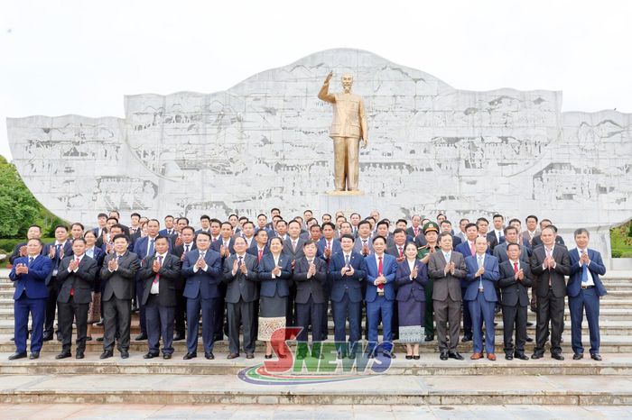 Các đại biểu chụp ảnh bên Tượng đài "Bác Hồ với đồng bào các dân tộc Tây Bắc" tại Quảng trường Tây Bắc.