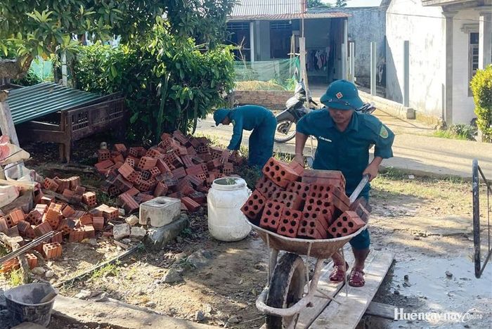 Lực lượng dân quân xã A Lưới 2 hỗ trợ vận chuyển vật liệu xây dựng nhà ở cho các hộ dân.