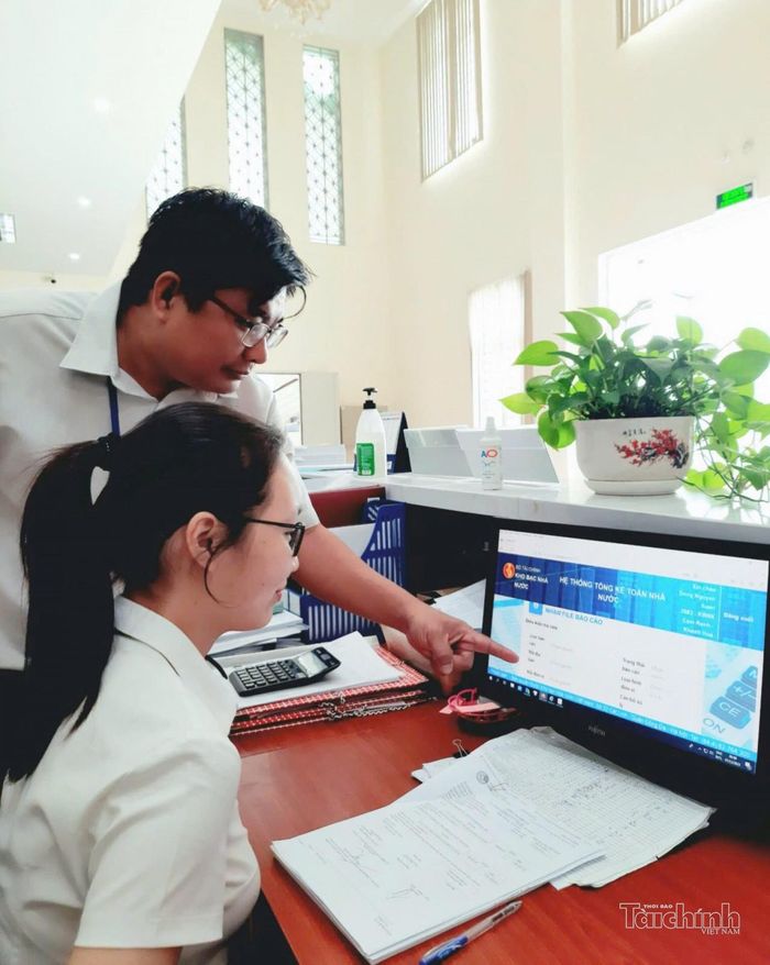 Công chức Kho bạc Nhà nước Khu vực XIV hướng dẫn, kiểm tra hồ sơ trên hệ thống điện tử. Ảnh: Lạc Nguyên