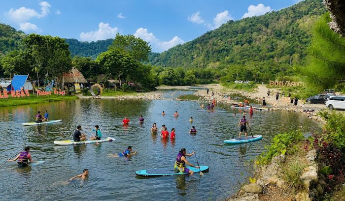 Du khách tắm suối, chèo SUP và tận hưởng không gian trong lành tại Suối La Ngâu, điểm đến ngày càng thu hút du khách yêu thiên nhiên. Ảnh: Tường Quang.
