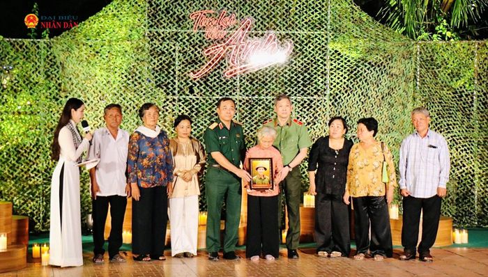 Gia đình liệt sĩ Huỳnh Văn Quên nhận di ảnh phục dựng của liệt sĩ. Ảnh: Hoa Lê