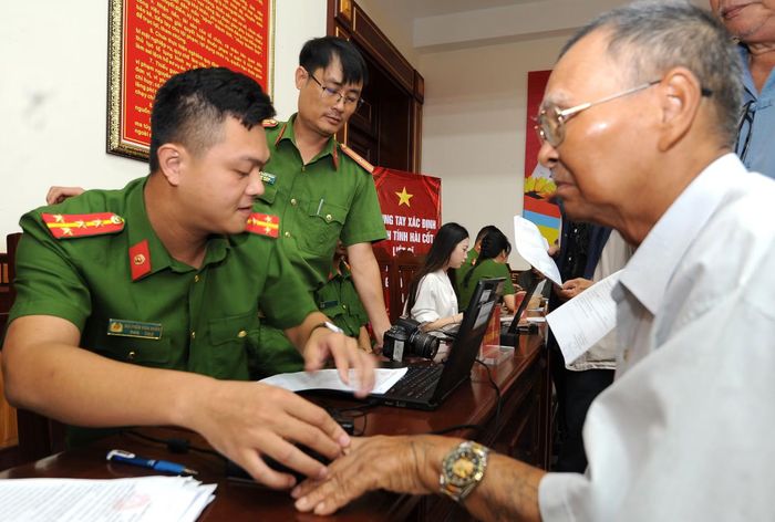 Thân nhân liệt sĩ được cán bộ, chiến sĩ Công an tận tình hướng dẫn thực hiện các bước lấy mẫu.