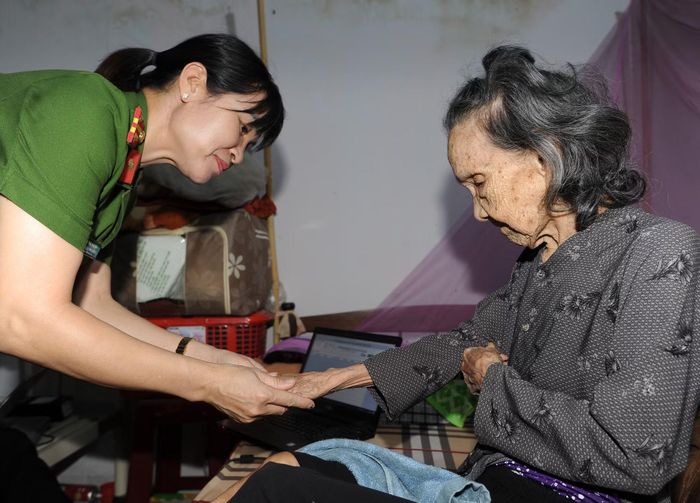 Cán bộ, chiến sĩ ân cần động viên, chia sẻ với cụ H Prũn Byă trong quá trình lấy mẫu ADN.