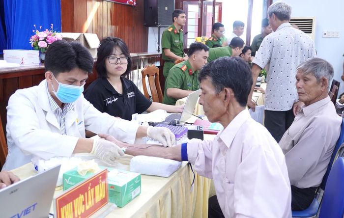 Lấy mẫu sinh phẩm từ thân nhân liệt sĩ ở xã Vạn Ninh để giám định ADN.