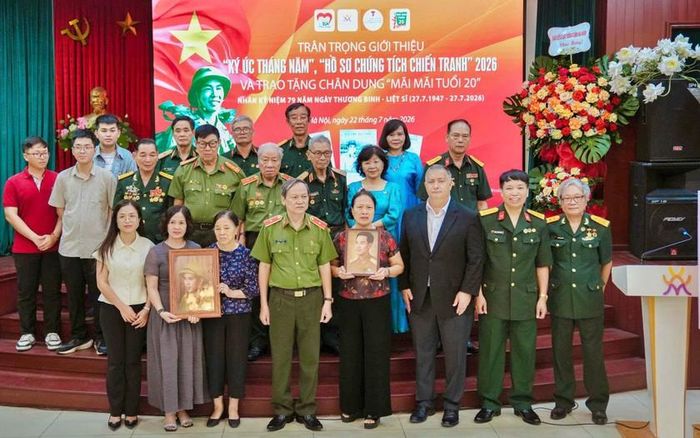 Đại diện thân nhân các gia đình liệt sĩ tiếp nhận những di ảnh chân dung thuộc dự án "Mãi mãi tuổi 20" do nhóm họa sĩ trẻ của "Trái tim người lính" phục dựng.