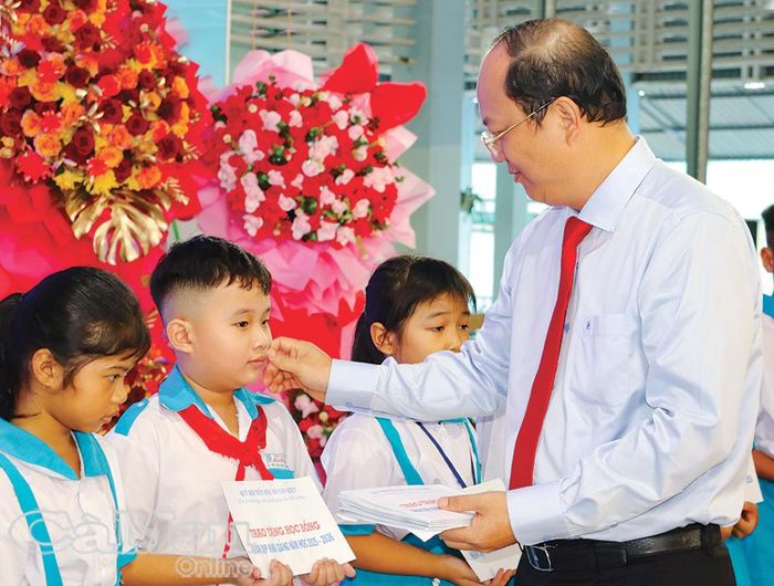 Bí thư Tỉnh ủy Nguyễn Hồ Hải trao học bổng cho các em học sinh. Ảnh: TRÚC LINH