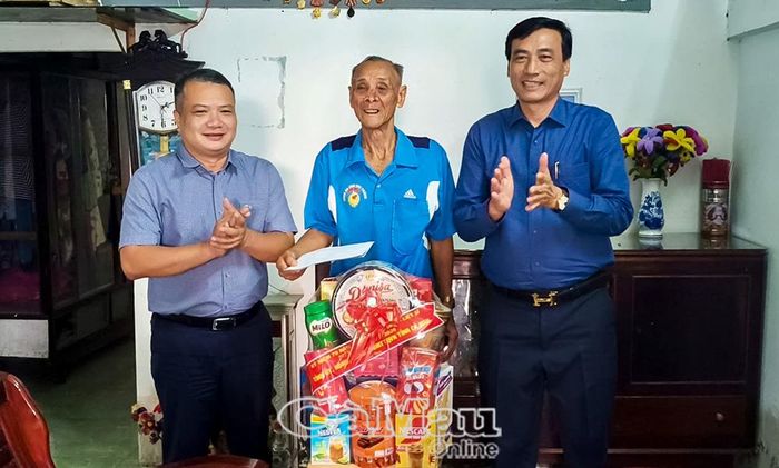 Chánh Văn phòng Tỉnh ủy Lê Tuấn Hải (bìa trái) tặng quà tri ân thương binh Lâm Quốc Chiến, ấp Cái Tràm A1.