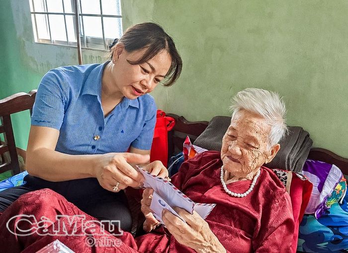  Đồng chí Lâm Ngọc Trân, Phó Bí thư Thường trực Đảng ủy xã Tân Hưng, trao tặng quà cho Mẹ Việt Nam anh hùng Lý Thị Năm.