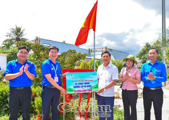  TS. Nguyễn Ngọc Trung, Phó hiệu trưởng Trường Đại học Sư phạm Thành phố Hồ Chí Minh, trao kinh phí hỗ trợ công trình "Đường cờ Tổ quốc" cho lãnh đạo xã Thới Bình.