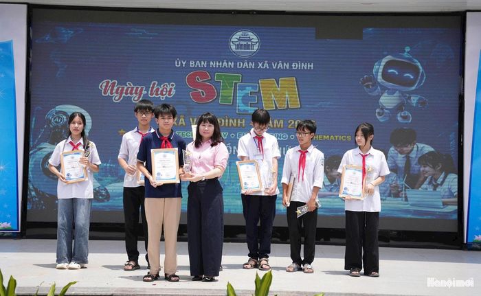 Phó Chủ tịch UBND xã Vân Đình Phạm Thúy Hòa trao giải Nhất cho đại diện học sinh Trường THCS Nguyễn Thượng Hiền. Ảnh: Lại Tấn