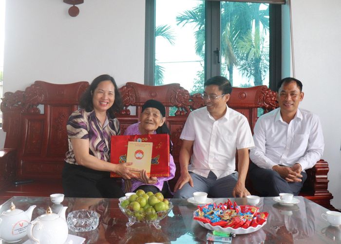 Phó Chủ tịch Ủy ban MTTQ Việt Nam thành phố Nguyễn Thị Thu Huyền tặng quà Bà mẹ Việt Nam Anh hùng Đinh Thị Lê. Ảnh: Hiền Chi