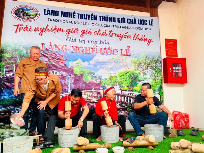 Người dân và du khách trải nghiệm công đoạn giã giò, gói chả thủ công tại làng giò chả Ước Lễ (xã Dân Hòa). Ảnh: Ánh Ngọc 