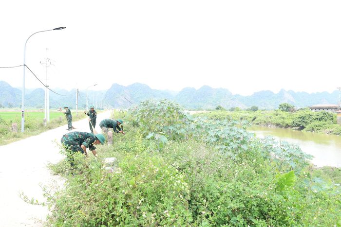 Chiến sĩ các đơn vị quân đội hỗ trợ xã Hương Sơn làm sạch bờ sông Mỹ Hà, nâng cao năng lực tiêu thoát lũ. Ảnh: Kim Nhuệ