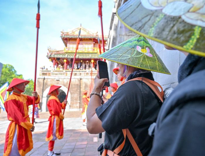 Hai mẹ con theo dõi lễ đổi gác tại cổng Ngọ Môn, Đại nội Huế, sáng 24/7. Ảnh: TTBTDTCĐH.