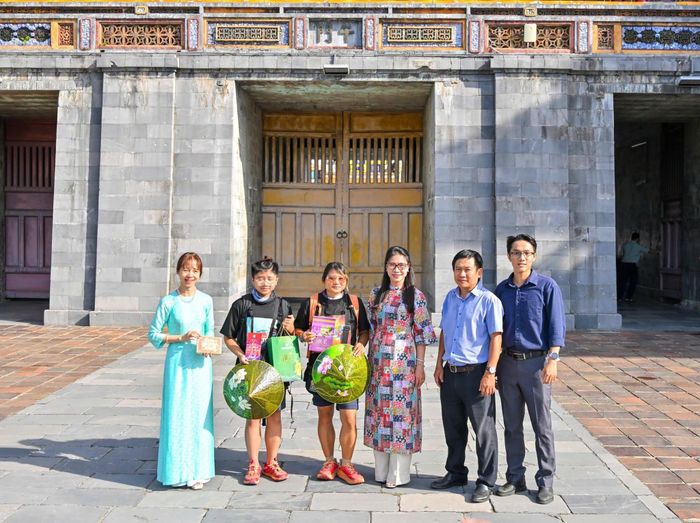 Đại diện Sở Du lịch Huế, Trung tâm Bảo tồn Di tích Cố đô Huế chào đón hai mẹ con Hà Phương tại cổng Ngọ Môn, Đại nội Huế, sáng 24/7. Ảnh: TTBTDTCĐH.