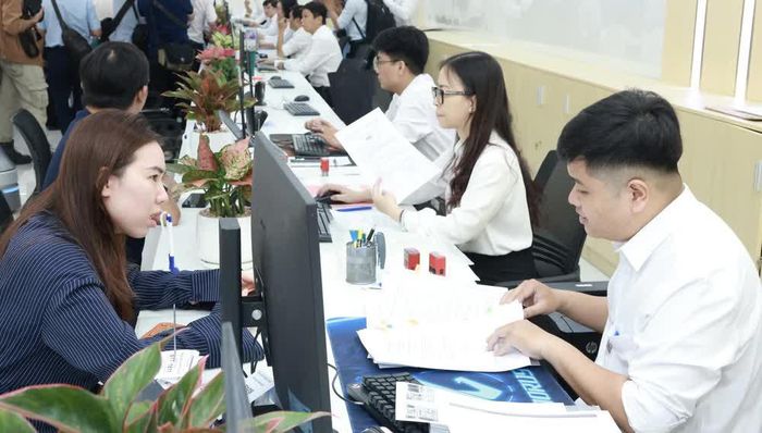 Chuyên viên tiếp nhận hồ sơ của người dân, doanh nghiệp tại Trung tâm Phục vụ hành chính công Thành phố Hồ Chí Minh. Ảnh: Xuân Anh – TTXVN
