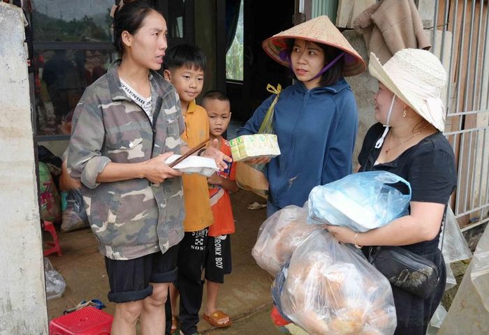 Tiếp tế thực phẩm cho những gia đình bị lũ cuốn trôi. Ảnh: Nguyễn Oanh - TTXVN