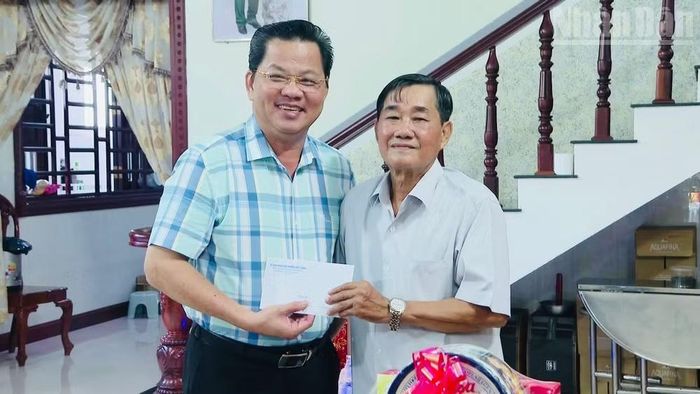 Đồng chí Lâm Danh Nhân (trái), Chủ tịch Ủy ban nhân dân phường Hiệp Thành, tặng quà gia đình chính sách.