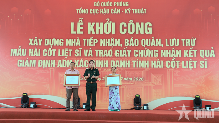 Thượng tướng Nguyễn Văn Gấu trao quyết định về việc đính chính thông tin trên bia mộ liệt sĩ cho thân nhân 2 liệt sĩ.
