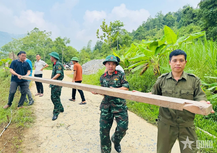  Các lực lượng tham gia vận chuyển vật liệu hỗ trợ xây dựng nhà ở cho gia đình ông Nguyễn Hải Dương, thôn Bản Mịch, xã Thuận Hòa. 