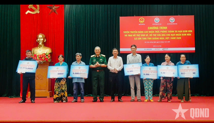 Trung tướng Nguyễn Đức Soát và ông Huỳnh Văn Tịnh, Phó bí thư Thường trực Đảng ủy xã Sơn Tịnh trao hỗ trợ sinh kế cho nạn nhân bom mìn. 