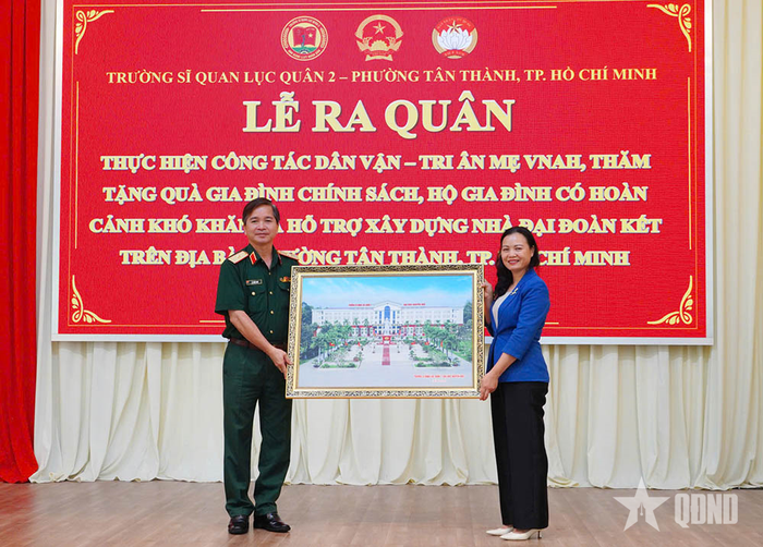 Thiếu tướng Lê Khắc Huy, Phó chính ủy nhà trường trao bức ảnh tặng địa phương trong lễ ra quân dân vận.