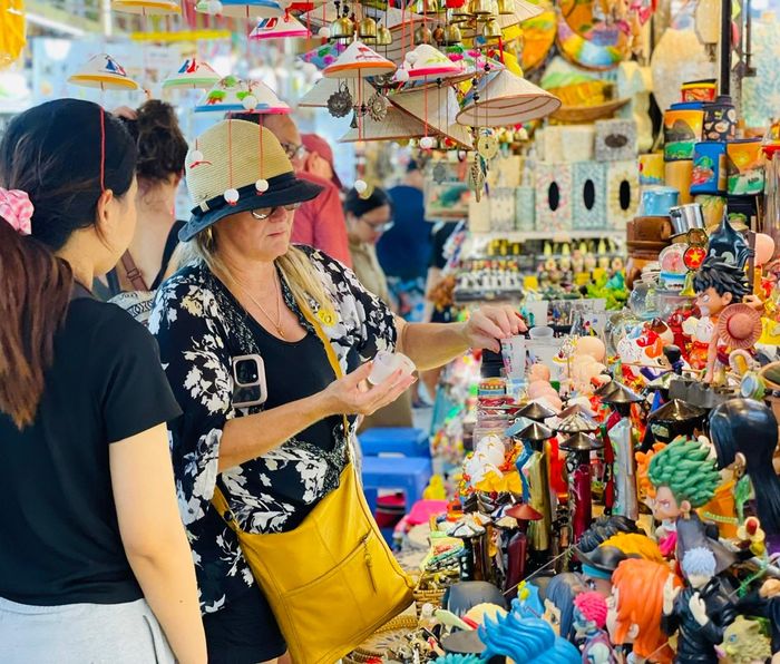  Du khách quốc tế mua hàng lưu niệm tại chợ Bến Thành. Ảnh: THI HỒNG 