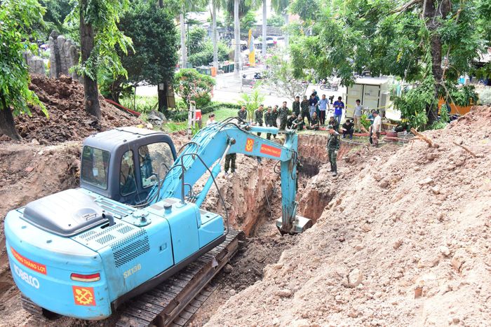 Lực lượng chức năng đưa máy xúc tiến hành đào tại khu đất cao trong Công viên Lê Thị Riêng để tìm kiếm hài cốt liệt sĩ