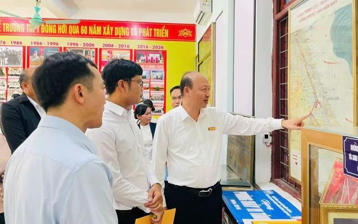 Ông Hoàng Văn Hải, Hiệu trưởng Trường THPT Đồng Hới, giới thiệu Phòng Truyền thống với đoàn công tác Sở Giáo dục và Thể thao tỉnh Khăm Muồn.