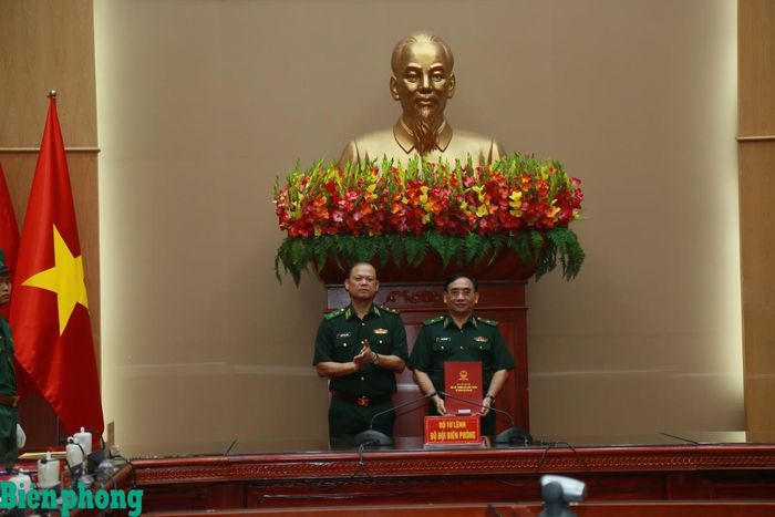 Thưìa ủy quyền của Bộ trưởng Bộ Quốc phòng, Trung tướng Nguyễn Anh Tuấn trao quyết định của Bộ Quốc phòng về việc bổ nhiệm lại chức danh Cục trưởng Cục Phòng, chống ma túy và tội phạm Bộ đội Biên phòng đối với Thiếu tướng Đỗ Ngọc Cảnh. Ảnh: Cẩm Linh