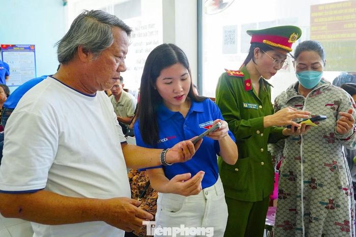 Các tình nguyện viên hỗ trợ người dân thực hiện các tiện ích số trên VNeID.