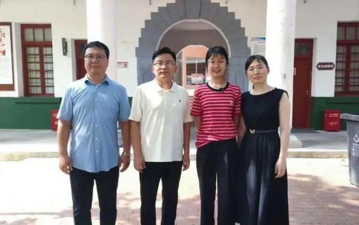 Hứa Dật Phương (mặc áo đỏ, đứng thứ 2 từ phải sang trái), chụp ảnh cùng các giáo viên trường THCS của em. Các thầy cô giáo cũ khen ngợi em là cô học trò kiên trì và có tư duy độc lập. Ảnh: 163.com