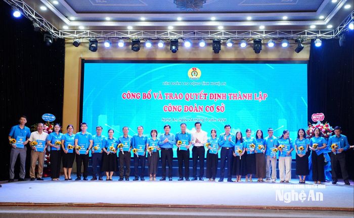 Các đồng chí Nguyễn Xuân Hùng - Phó Chủ tịch Tổng Liên đoàn Lao động Việt Nam; Nguyễn Đình Hùng - Ủy viên Ban Thường vụ Tỉnh ủy, Phó Chủ tịch Thường trực Ủy ban Mặt trận Tổ quốc Việt Nam tỉnh; Kha Văn Tám - Phó Chủ tịch Ủy ban Mặt trận Tổ quốc Việt Nam tỉnh, Chủ tịch Liên đoàn Lao động tỉnh trao quyết định, tặng hoa chúc mừng các công đoàn cơ sở. Ảnh: Mai Hương