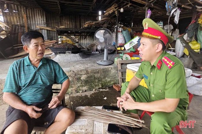 Đại úy Trần Nguyễn Hoàng trao đổi với ông Thái Đăng Trình - chủ hộ làm nghề chế biến hến về công tác đảm bảo an toàn PCCC trong khu làng nghề.