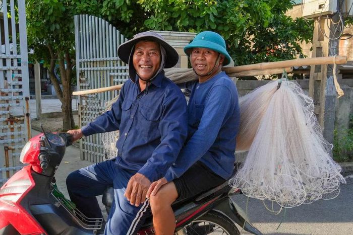 Ngư dân phường Hải Ninh cùng nhau mang ngư cụ ra biển để kéo lưới rùng. (Ảnh: Hữu Quyết/TTXVN)